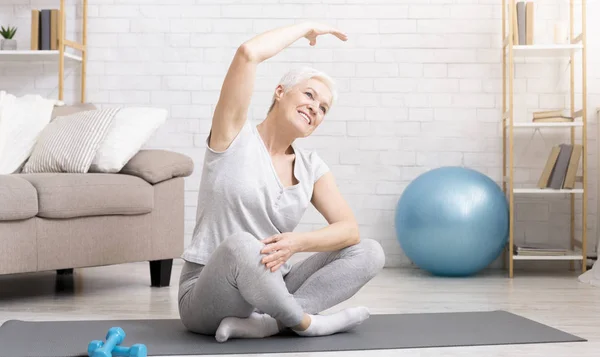 Mulher idosa ativa fazendo exercícios em casa — Fotografia de Stock