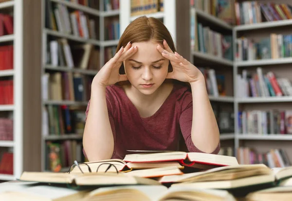 Συγκεντρωμένη κορίτσι σπουδάζει στη βιβλιοθήκη, προετοιμασία για τις εξετάσεις — Φωτογραφία Αρχείου