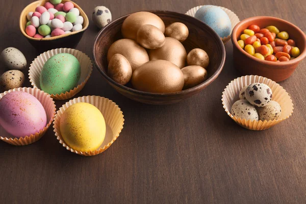 Цветные яйца и конфеты на тёмном фоне — стоковое фото