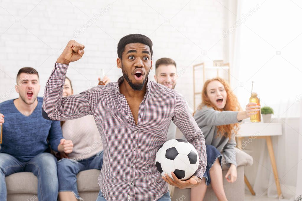 Goal. Excited friends watching football match at home