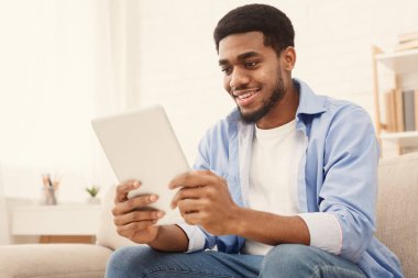 Evde dijital tablet kullanarak genç bin yıllık adam