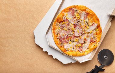 Ahşap arka planda teslimat kutusu ve kesici pizza