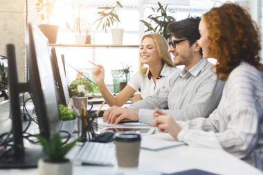 Ofiste bilgisayarlarda birlikte çalışan genç proje ekibi