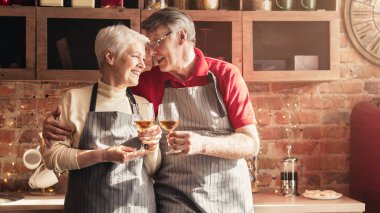 Sevgi dolu Senior çift mutfakta şarap ile tezahürat