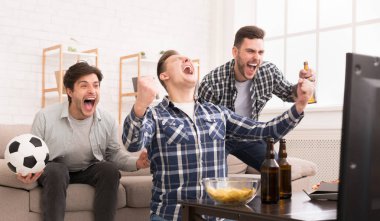 Kazanan. Evde futbol izlerken heyecanlı arkadaşlar