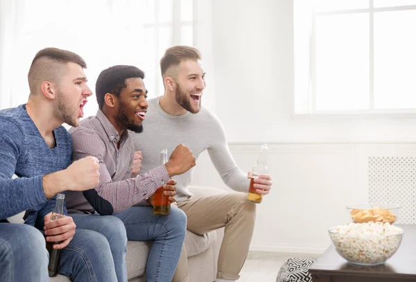 Diversos amigos animando a su equipo favorito en casa —  Fotos de Stock