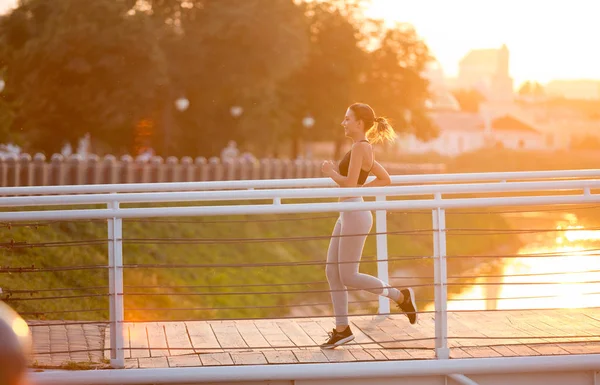 Alegre deportista corriendo en puente en la mañana — Foto de Stock