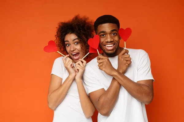 Heureux couple afro-américain tenant des coeurs de papier rouge — Photo