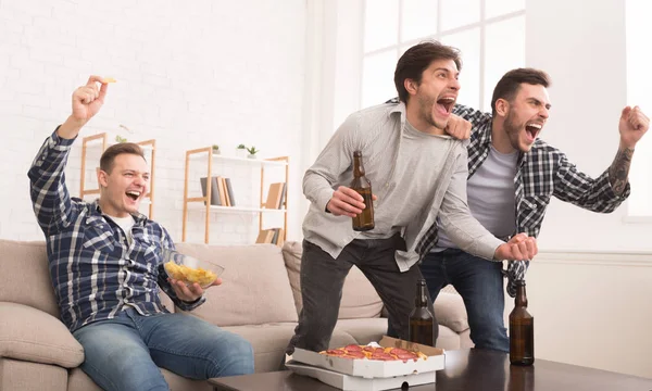 Felices aficionados al fútbol viendo el fútbol en la televisión y celebrando la victoria —  Fotos de Stock