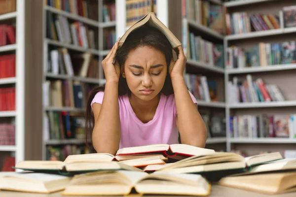 Hangsúlyozta, fekete lány diák készül vizsgálatra könyvtár — Stock Fotó