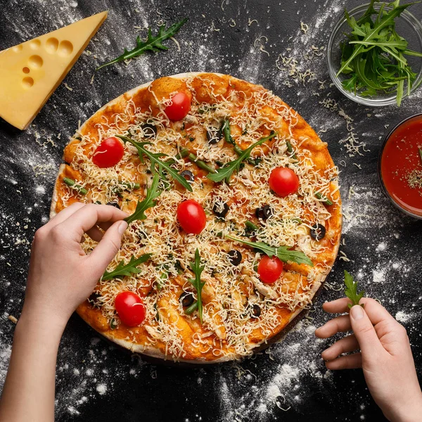 Frau dekoriert Pizza mit Rucola-Salat — Stockfoto