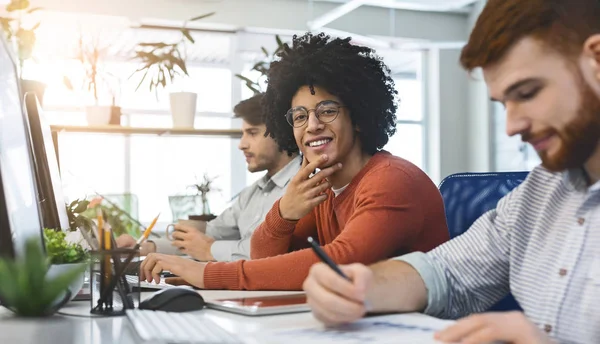 Trabajo en la empresa de TI, tipo negro amigable sonriendo a la cámara — Foto de Stock