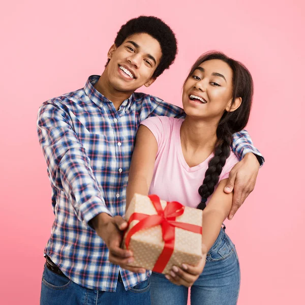 Joyeux couple embrassant et tenant boîte cadeau — Photo