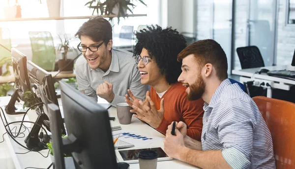 Drie jonge mannen genieten van goede codering baan op de computer — Stockfoto