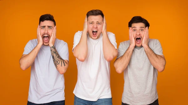 Shocked men with open mouth over orange background