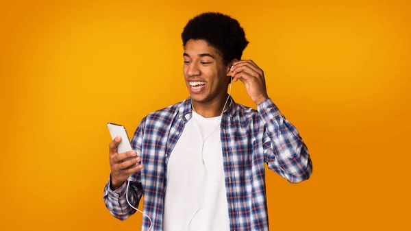 Disfruta la música. Chico feliz con auriculares y teléfono — Foto de Stock