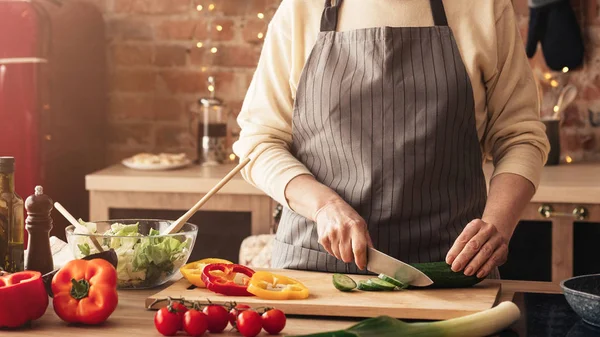 Reife Frau kocht frischen Gemüsesalat in Küche — Stockfoto