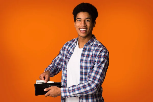Економія грошей. Афро-американський хлопець покласти банкноти в гаманець — стокове фото