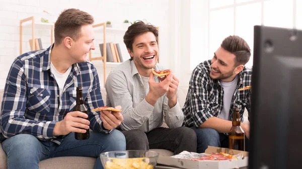 Amigos comiendo pizza y hablando, viendo la televisión — Foto de Stock