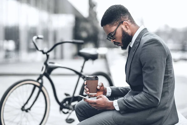 Bonito homem de negócios navegando na internet durante o coffee break — Fotografia de Stock