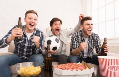 Hedef. Evde futbol maçı izleyen mutlu adamlar