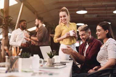 Proje üzerinde çalışan iş arkadaşları, işyerinde dizüstü bilgisayar kullanma