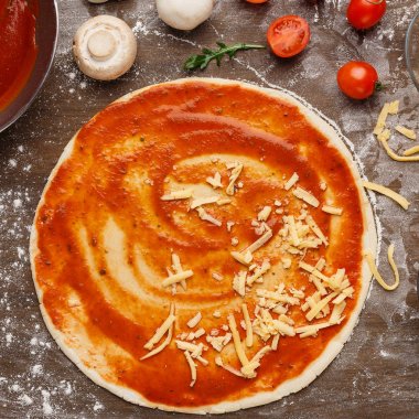 Pişirme süreci. Rendelenmiş peynirile unbaked pizza