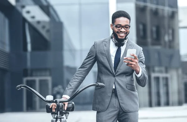 Αφροαμερικανός επιχειρηματίας με smartphone που στέκεται με ποδήλατο — Φωτογραφία Αρχείου