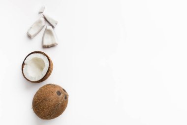 Whole and chopped coconuts on white