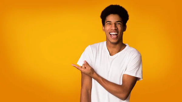 Concepto de publicidad. Chico feliz apuntando en el espacio vacío — Foto de Stock