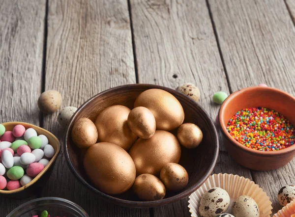 Пасхальные яйца окрашены в золотой цвет в деревянную чашу — стоковое фото