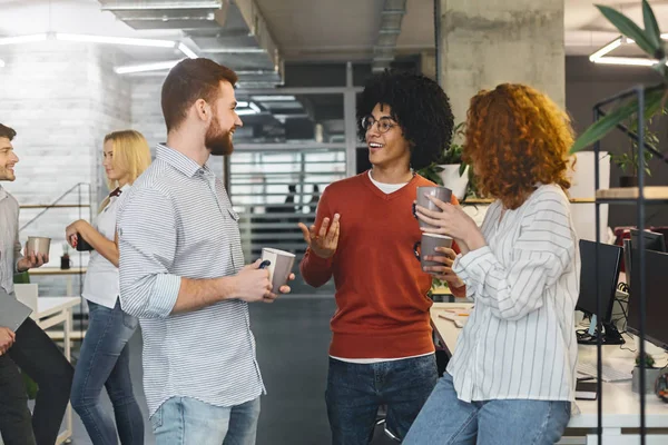 Diversos millennials disfrutando de la comunicación en la oficina moderna — Foto de Stock