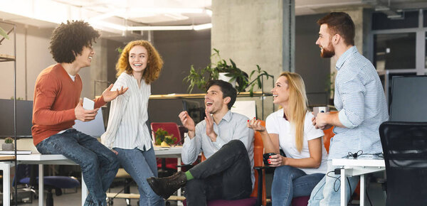 Diverse millennial people having good talk at coworking space