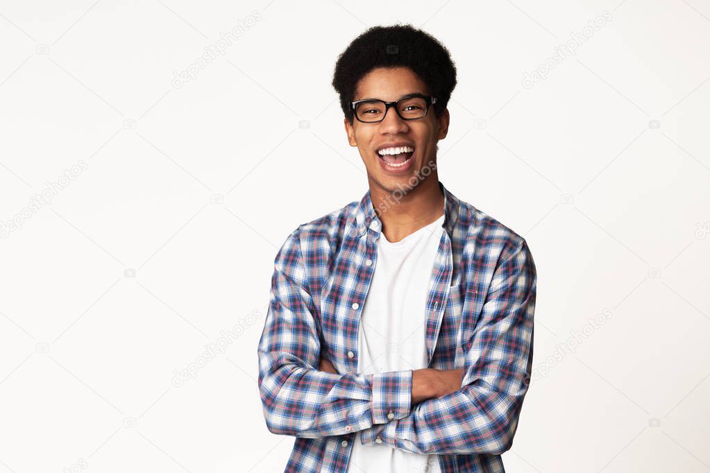 Successful student posing with crossed hands, light background