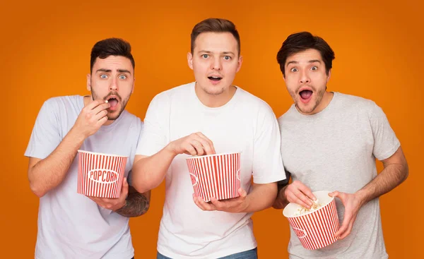 Amici interessati mangiare popcorn e guardare film — Foto Stock