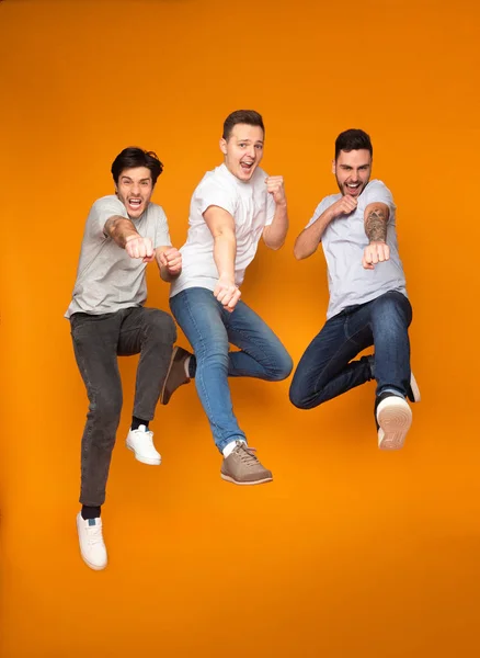 Tiga pria bersemangat melompat bersama-sama, bersenang-senang — Stok Foto