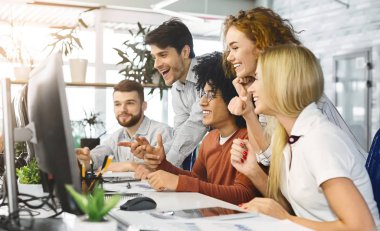 Young team looking at computer screen in office together