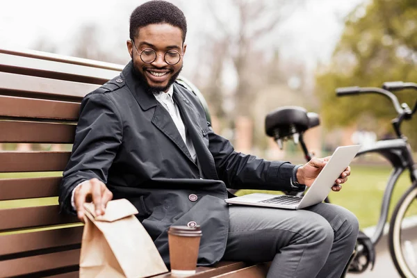 No time for break. Young businessman using laptop outdoors