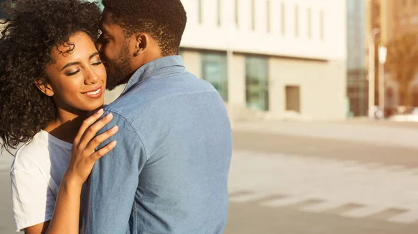 Whispering about love. Man embracing his girlfriend in city — Stock Photo, Image