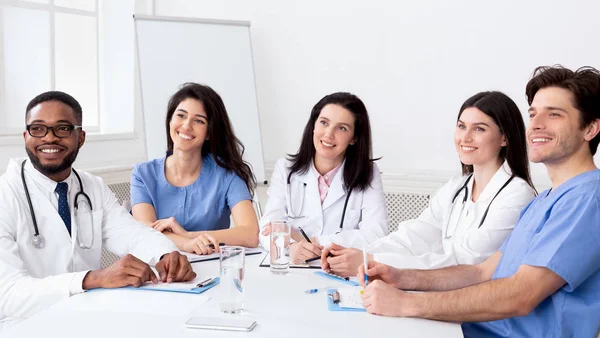 Junge Praktikanten hören Professor im Konferenzraum zu — Stockfoto