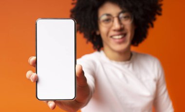 Afrikalı-Amerikan milenyal adam boş cep telefonu ekran gösteren