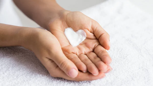 Love your body. Female hands with cream in heart shape — Stock Photo, Image