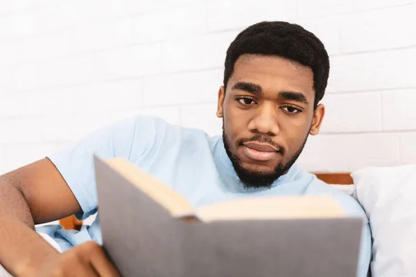 Uomo nero che studia letteratura d'affari a letto — Foto Stock