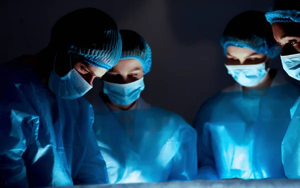 Equipo de cirujanos profesionales que realizan cirugía en el hospital —  Fotos de Stock