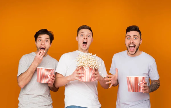 Homens chocados comendo pipocas e assistindo filme assustador — Fotografia de Stock