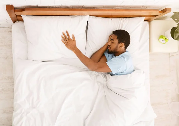 Egy fiatal fekete srác, aki ártatlanul alszik az ágyában. — Stock Fotó