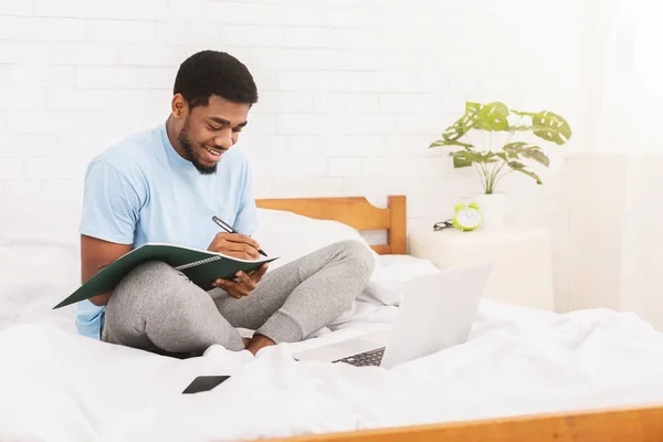 Fröhliche schwarze Studentin lernt online im Bett — Stockfoto