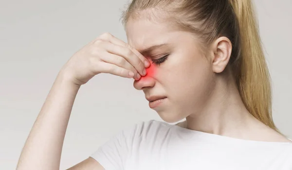 Mujer triste sosteniendo la nariz porque el dolor sinusal — Foto de Stock