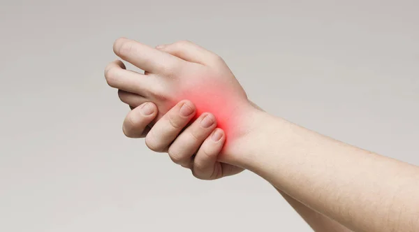 Duizendjarige vrouw aanraken van haar ontstoken pijnlijke hand — Stockfoto