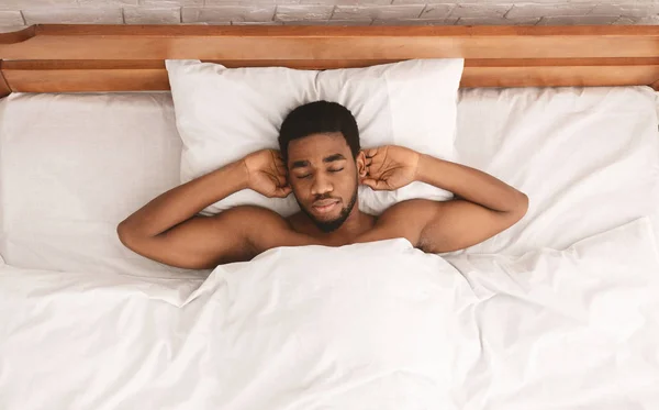 Relaxed black guy lying with hands behind head — Stock Photo, Image